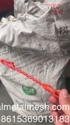 Rode plastic steunclips die tussen het prikkeldraad en de draad gaan